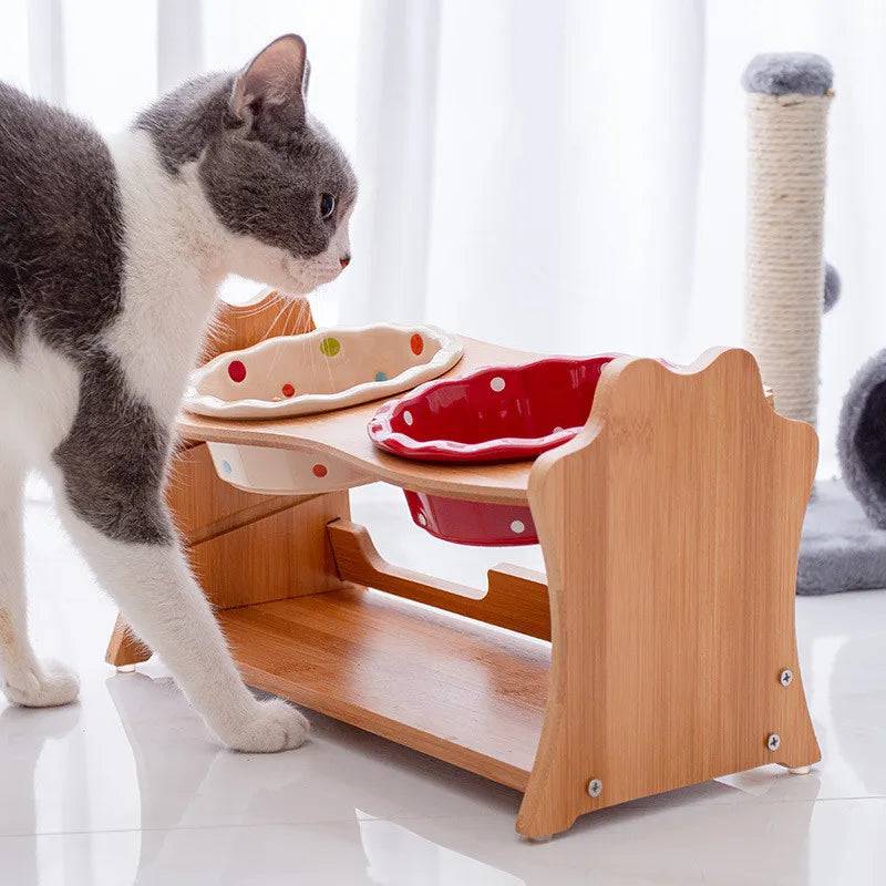 White raised ceramic double bowl stand for dogs and cats on wooden table, used for food and water bowls by Pawciara.