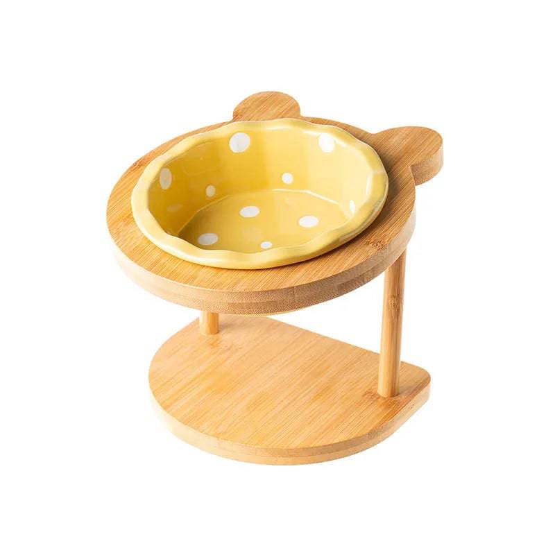 Raised ceramic double bowl stand for dogs and cats by Pawciara, with white ceramic dishes on a wooden stand for food and water.