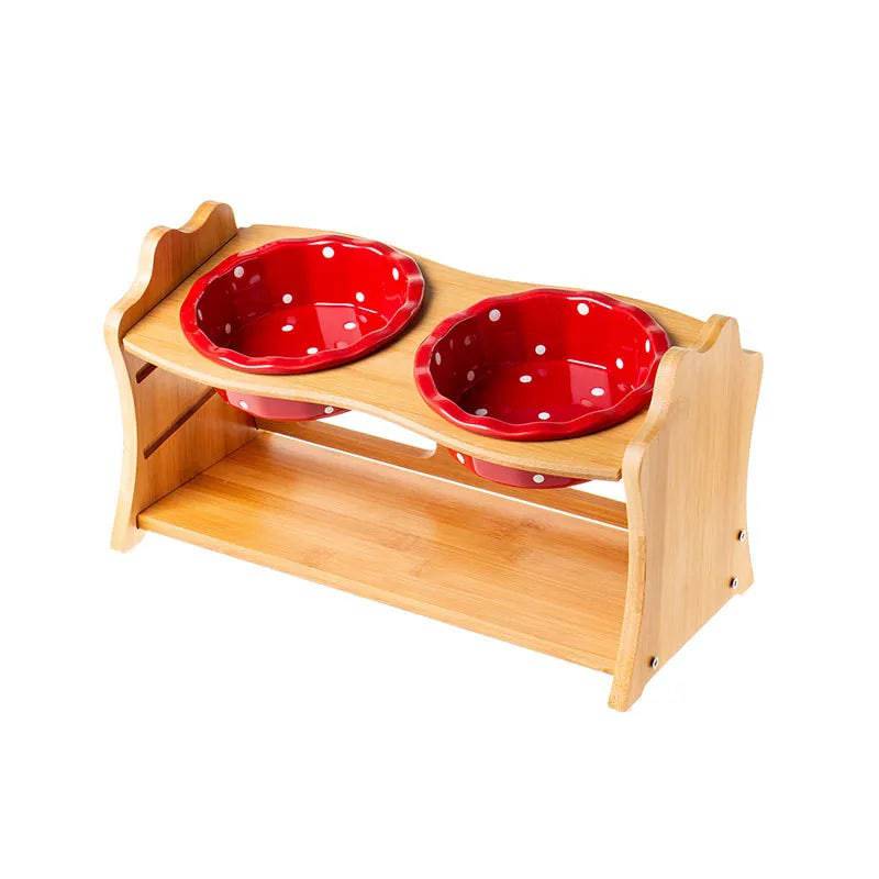 Raised ceramic double bowl stand by Pawciara with white ceramic bowls for dogs and cats, placed on a wooden table.