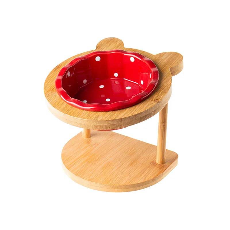 Raised ceramic double bowl stand for dogs and cats with white ceramic dishes on a wooden table, ideal for pet food and water.